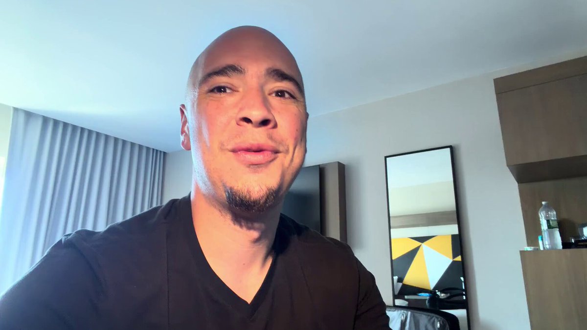 The image shows a man wearing a black shirt, smiling at the camera while posing for a photo. The caption of the image reads "Focus on what is in the image and how it relates to the post."