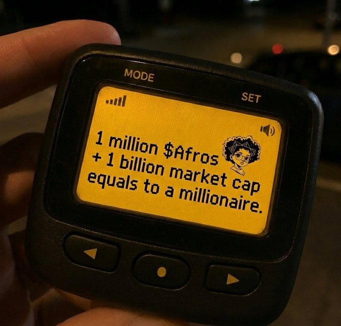 A handheld electronic device displaying the message "1 million $Afros + 1 billion market cap equals to a millionaire" alongside a cartoon character avatar.