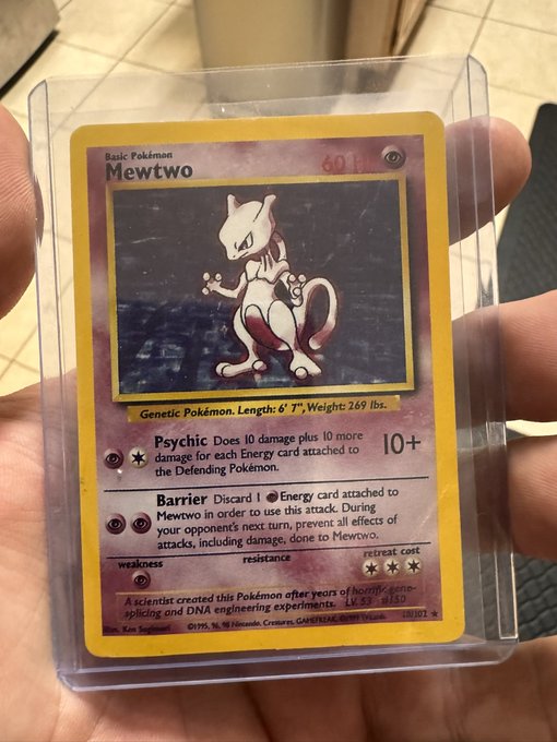 A person holds a Mewtwo Pokémon card (a Genetic Pokémon, 60 HP, from Base Set, ©1995-96 Nintendo) in a clear protective sleeve. The card's Psychic and Barrier attacks are visible, and its inclusion in the post ties into the excitement of receiving collectible card deliveries from @tatakaefyt.