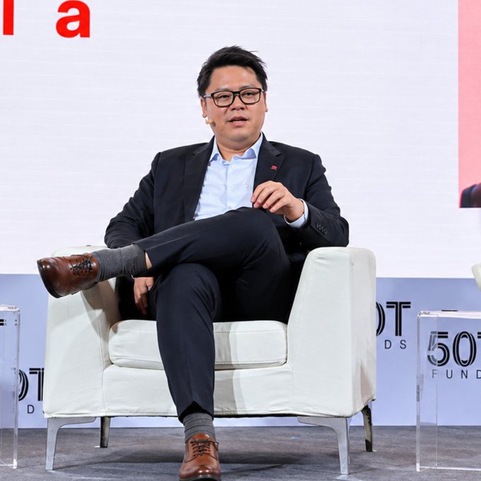 David Hui, Deputy CEO of DBS Digital Exchange, sits cross-legged on stage in a dark suit and glasses, addressing attendees at the Blockworks DAS conference, where he discussed DBS's plans to launch tokenized equities following their earlier successes with tokenized money and gold.