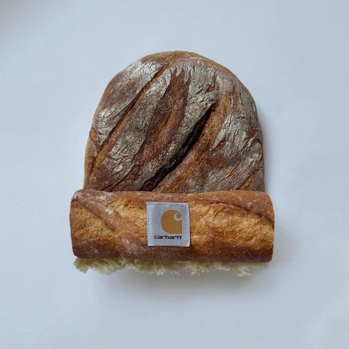 A rustic Carhartt beanie styled to look like it's made of sourdough bread, complete with a folded brim, flour dusting, and a white Carhartt logo patch on a plain white background.
