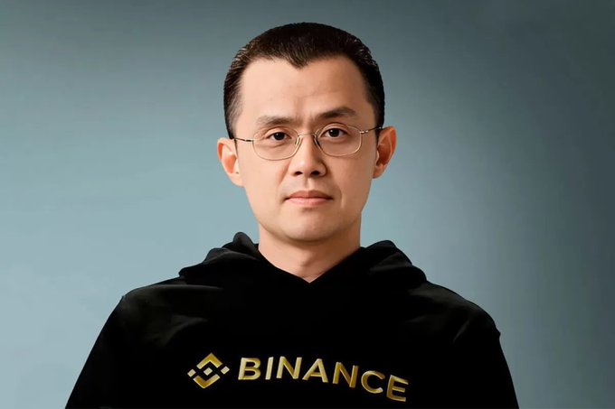 A man with glasses and a black hoodie featuring the "BINANCE" logo stands against a light blue background. The image relates to the post as it shows Binance founder Changpeng Zhao (CZ), who is making the bold Bitcoin price prediction.