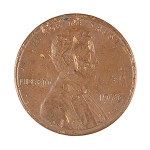 A close-up photograph of a worn 1976 Lincoln penny showing 'IN GOD WE TRUST' and 'LIBERTY' inscriptions with the date 1976 visible.
