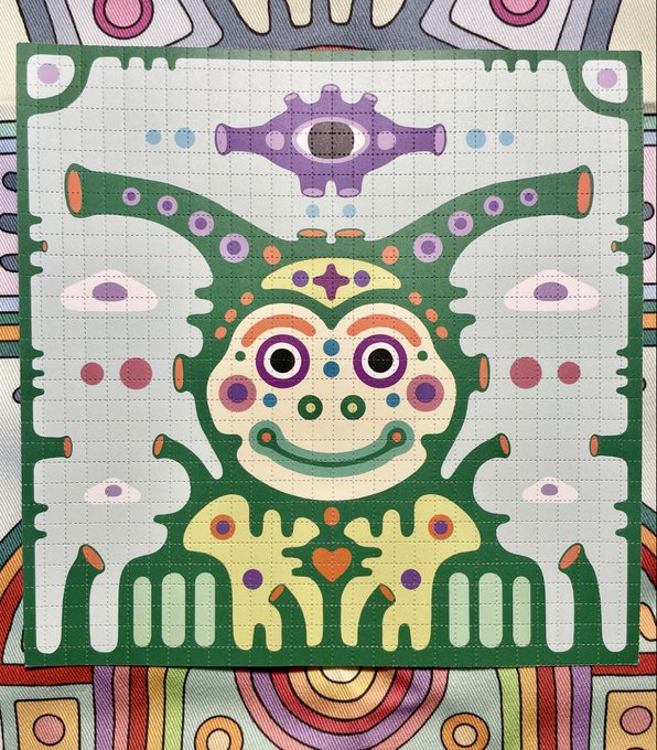 A colorful symmetrical patterned artwork featuring a whimsical creature with horns, large eyes, and decorative purple and orange details on a grid background, reminiscent of textile or pixel art design.