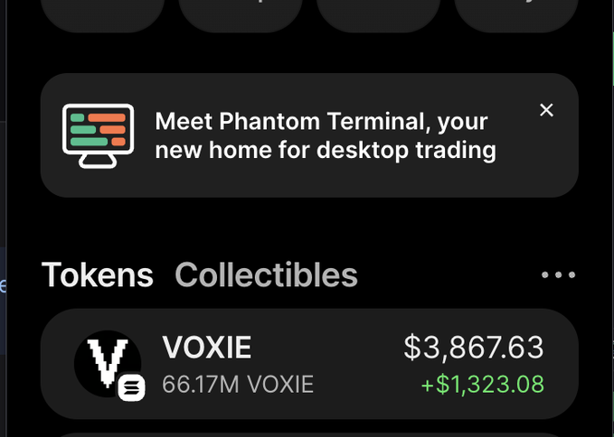 A mobile app interface showing a notification "Meet Phantom Terminal, your new home for desktop trading" and a "Tokens Collectibles" section displaying "VOXIE 66.17M VOXIE $3,867.63 +$1,323.08".