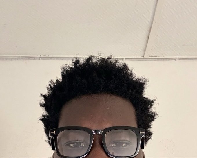 The image features a person wearing glasses, with their face partially obscured by them. The person has black hair and is looking directly at the camera. There are no other objects or people visible in the image, so we can only focus on this individual's appearance and expression. The caption provided seems to be unrelated to the main subject of the photo and does not provide any additional information about the context or content of the post.