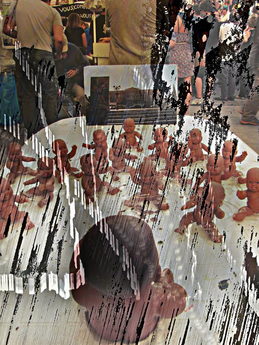 A distorted, glitchy photograph shows a collection of small baby figurines arranged on a surface, with people visible in the background at what appears to be a market or show.