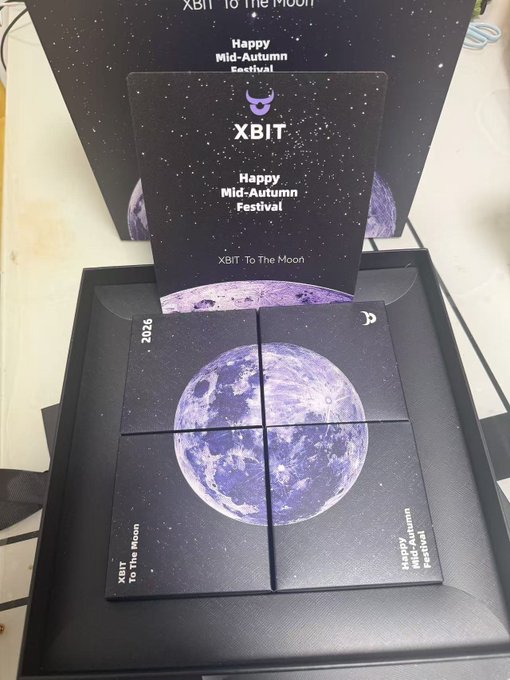 A black gift box set from XBIT containing four smaller boxes arranged to form a moon image, accompanied by a card reading 'Happy Mid-Autumn Festival' and 'XBIT · To The Moon'.