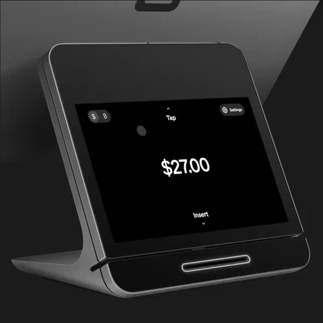 A close-up of a card payment terminal displaying a tap-to-pay amount of $27.00.