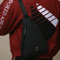 A person wearing a maroon 'Cincinnati Bearcats' shirt with a black Nike sling bag across their chest.