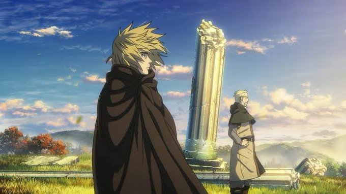 Anime artwork depicting two cloaked figures standing in a grassy field near stone ruins and a broken column under a cloudy blue sky, with one character having blonde hair.