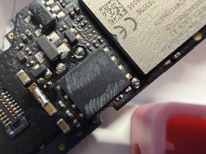 A close-up photo of a circuit board showing an ESP32 chip with a visible fingerprint smudge on its surface.