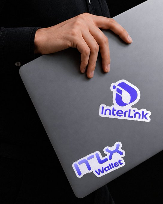 A person wearing a dark denim jacket holds a gray laptop displaying stickers for "InterLink" (with a purple droplet logo) and "ITLX Wallet," visually reinforcing the post's message about partnering with both platforms to build, connect, and advance the week's goals.