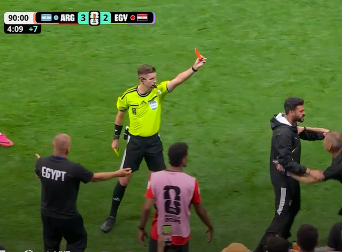 A soccer match scene showing a referee in yellow showing a red card to players, with the scoreboard indicating ARG 3 - 2 EGY at 90:00 with 4:09 of stoppage time.