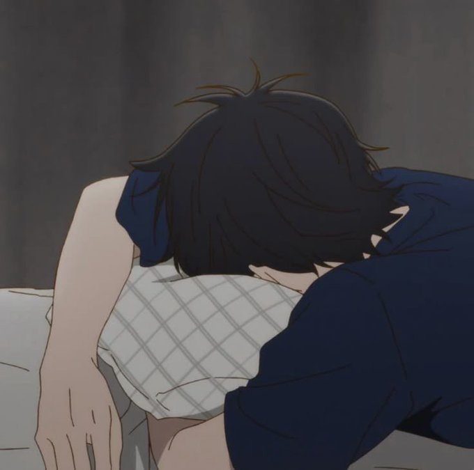 An anime-style image depicts a person with black hair burying their face into a white checkered pillow against a dark gray background.