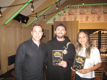 Three people pose with awards at what appears to be a 'Sharky Pucker Pokey Pub' event, with two of them holding plaques.