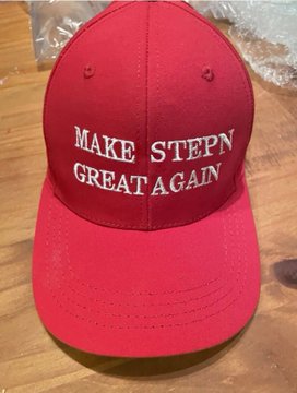 Red baseball cap with white embroidered text reading 'MAKE STEPN GREAT AGAIN', a parody reference to the STEPN crypto project.