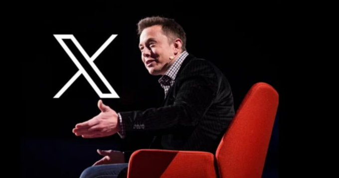 Elon Musk sits in a red chair on stage with the X (formerly Twitter) logo displayed behind him against a black background.