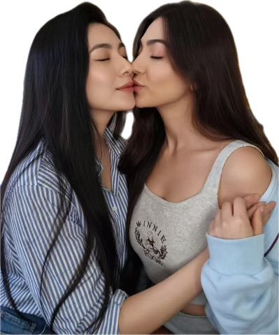 Two young women with long dark hair share a kiss against a white background. One wears a striped button-down shirt, while the other wears a grey "WINNIE" tank top and a light blue sweater.