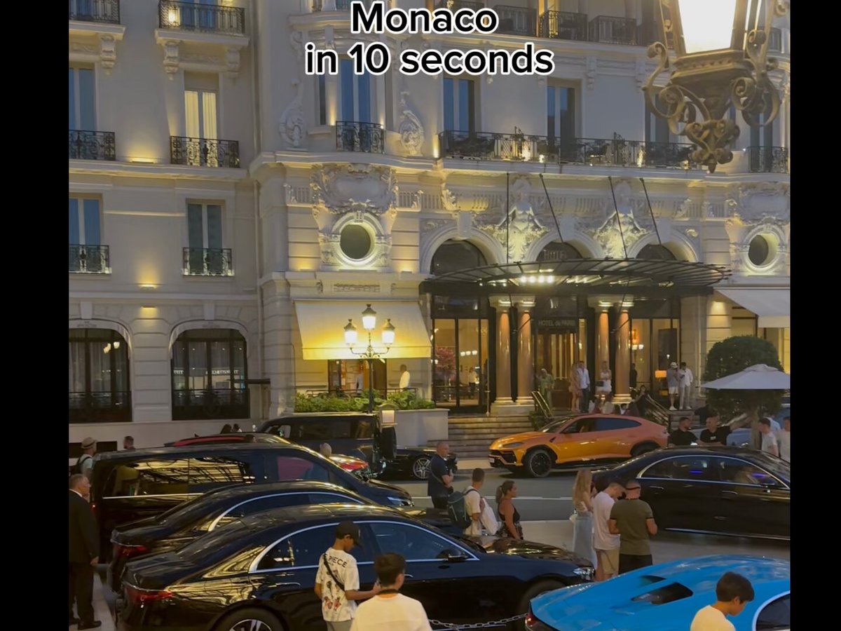 The image shows a busy street scene with people walking around, cars parked or driving by, and buildings lining the street. In the background, there are several cars of various colors, including black, white, and blue. The text "Monaco in 10 seconds" is visible on the image, suggesting that it was taken during a short period of time. The post also mentions Polymarket weather traders in Monaco, which could be related to the street scene or another topic.