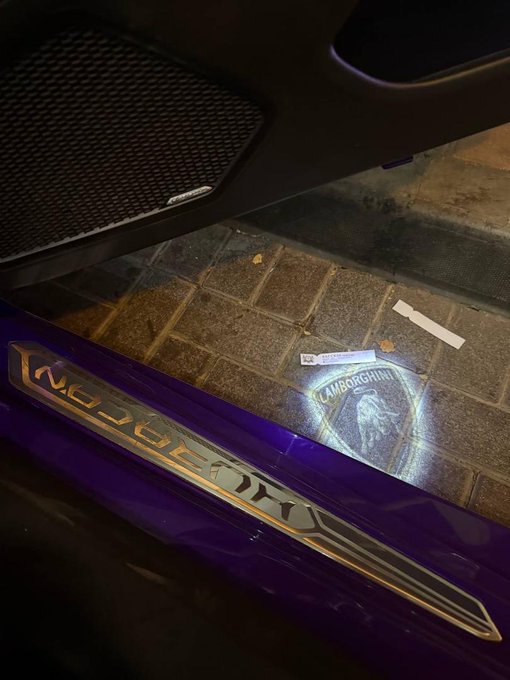 A Lamborghini illuminates a puddle with its logo and "Lamborghini" lettering on the side skirt, while a "Goodbye" message is projected in light—perhaps a fitting farewell to the trading week as the trader heads outside to enjoy Sunday and touch some grass.