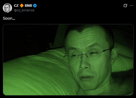 A tweet from CZ (@cz_binance) says 'Soon...' accompanied by a green-tinted photo of a man lying in bed.