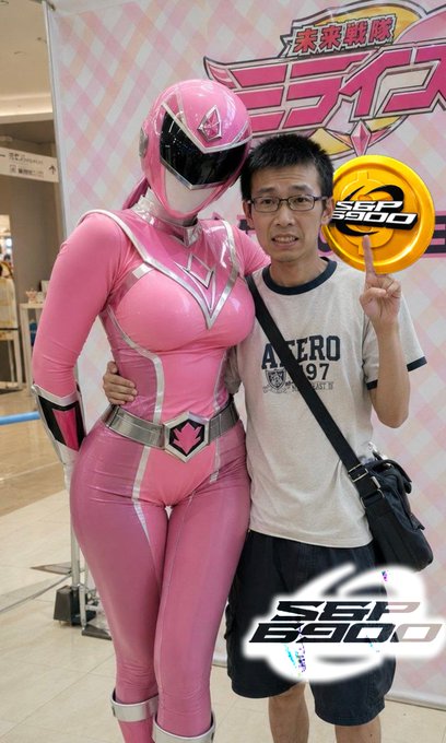 A man in an 'ASTERO 197' t-shirt posing with a pink Power Ranger cosplayer at what appears to be a Japanese event with 'SS890' branding.