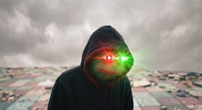 A figure in a dark hooded sweatshirt stands before a sprawling cityscape under a cloudy sky, with digitally added glowing red and green laser beams emanating from their eyes.