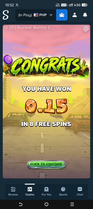 A mobile phone screenshot shows a casino app slot machine game called 'Nuclear Bombs 2' displaying a 'CONGRATS YOU HAVE WON 0.15 IN 8 FREE SPINS' message.
