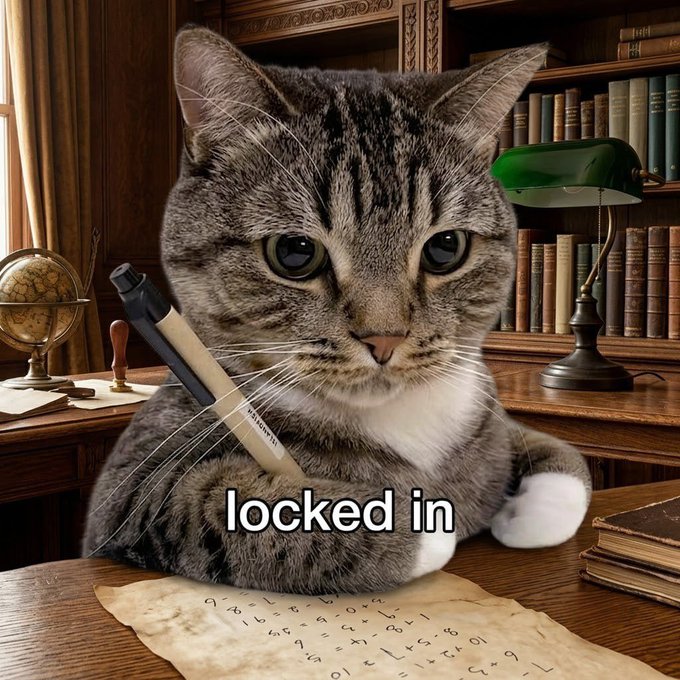 The image features a cat sitting at a desk with a piece of paper, which has the phrase "Locked in" written on it. The cat appears to be writing or drawing something on the paper using a pen. In the background, there are several books and a globe, suggesting that this scene takes place in an office setting. The caption for the image reads: "Big week ahead for Base memes. Stay locked in."