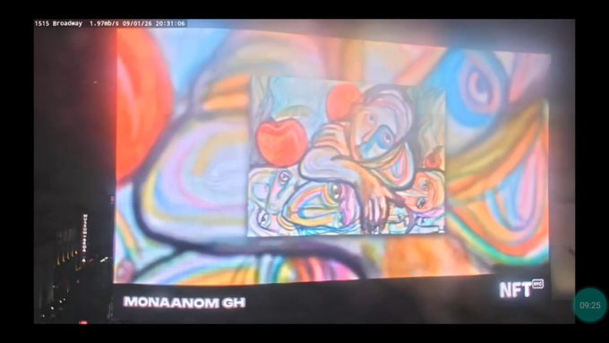 A photograph of a Times Square billboard displaying colorful, surreal abstract artwork branded with the artist's name "MONAANOM GH" and an "NFT NYC" logo in the corner, along with date and time stamps.