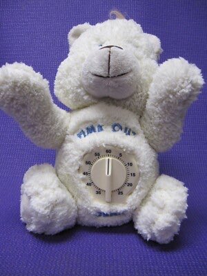 A plush white teddy bear-shaped kitchen timer sits against a purple background, featuring a circular dial in its belly marked 'TIME OUT' with numbers from 0 to 60.