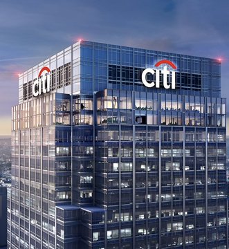 A Citi bank tower photographed at dusk with the illuminated Citi logo and red arch on the glass facade.