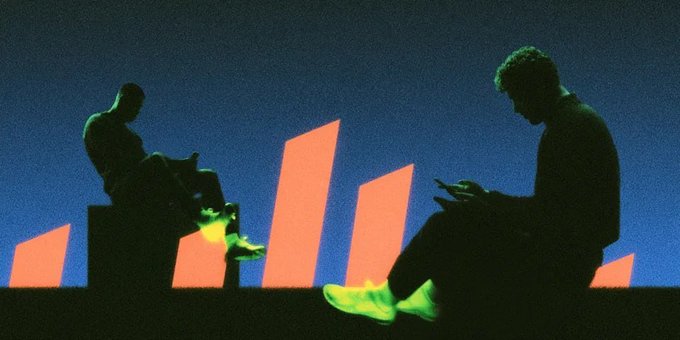 Stylized silhouette photo of two figures in dark clothing seated on steps against a blue background, illuminated by glowing neon green light on their shoes, with orange geometric shapes behind them.