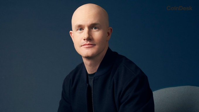 Coinbase CEO Brian Armstrong, pictured in a dark jacket against a navy blue backdrop with a CoinDesk watermark, as he publicly urges the U.S. Senate to hold a full floor vote on the CLARITY Act, arguing that crypto regulatory negotiations are complete and the status quo must change.