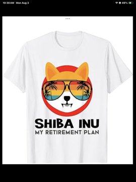 A white t-shirt displays a graphic of the Shiba Inu dog wearing sunglasses with a sunset reflection, accompanied by the text 'SHIBA INU MY RETIREMENT PLAN'.