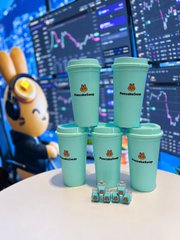 A cartoon rabbit mascot poses behind a tiered display of teal PancakeSwap-branded cups and mini mugs at the KBW official booth, promoting the limited-edition merchandise on its final day of availability.