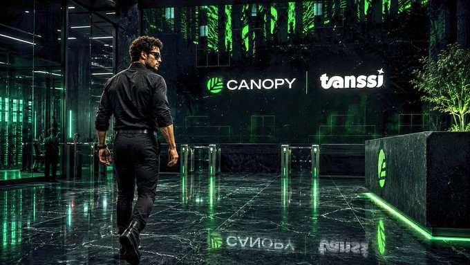 The image features a man walking past a large green sign for Canopy, which reads "CNPY Network". The man appears to be dressed in business attire with black pants and a black shirt. There are also two potted plants visible in the scene - one on the left side of the photo and another further back towards the right edge.