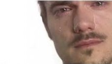 The image shows a close-up of a man with a mustache and goatee crying, with visible tears on his cheeks. This tearful, pleading face is used as a humorous, exaggerated reaction to express desperation and sincerity while begging a project to launch its token.