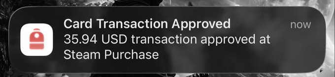 A mobile notification on a dark background reading 'Card Transaction Approved - 35.94 USD transaction approved at Steam Purchase' with a red lock icon and 'now' timestamp.