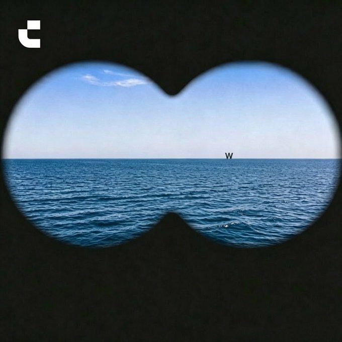 Viewed through binoculars, a distant "W" sits on the horizon over the open sea, illustrating the post's warning that danger may be closer than it appears.