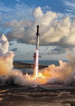 A SpaceX Starship rocket ascends through the sky during its historic 14th flight test, with massive clouds of exhaust billowing around the launch pad. The image captures the vehicle mid-liftoff, showcasing the successful test flight referenced in the accompanying post.