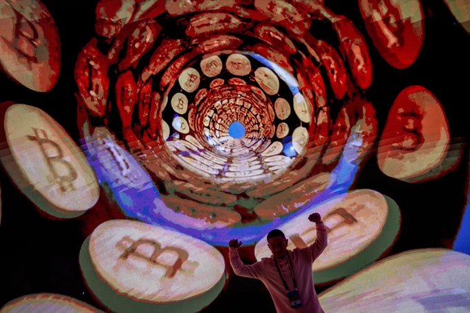 A man stands with arms raised triumphantly in front of a large screen displaying a swirling vortex of Bitcoin logos, symbolizing the cryptocurrency's recent surge to the $70,000 level driven by optimism from a Trump meeting and declining Treasury yields.