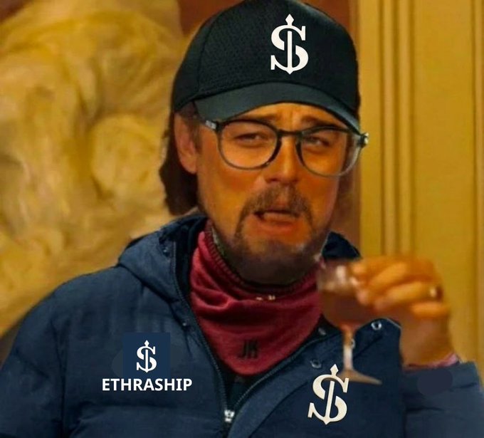 Man wearing a black cap with dollar sign logo, glasses, and a 'ETHRASHIP' badge holding a wine glass.