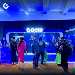 Attendees gather at a 'b.gate' booth, which is illuminated in bright blue light and advertises 'Sweat Aims Tokenized'.