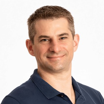A man with short brown hair wearing a dark blue polo shirt smiles at the camera, appearing to be Dave Ripley, co-CEO of Payward, the parent company of Kraken, as the post discusses the company's expansion into banking services and asset management outside the U.S.