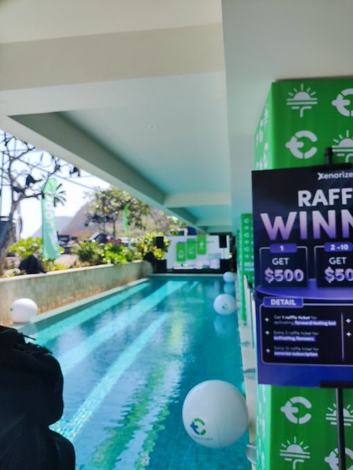 An outdoor or poolside area with a sign reading 'RAFFL WINNERS' offering 'GET $500' prizes, alongside a swimming pool with floating balls.