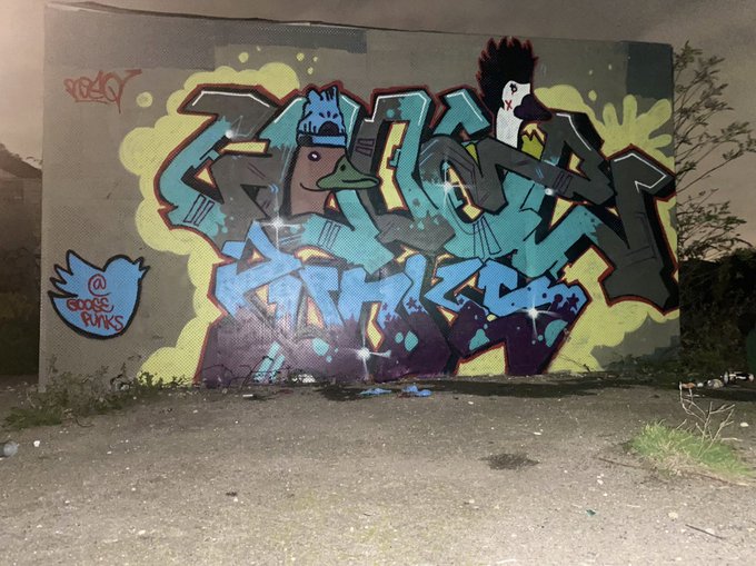 A graffiti piece reading 'GOOSE PUNKS' with Twitter '@goose_punks' handle covers a wall in vibrant blues, purples, and yellows.
