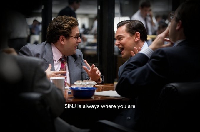 A scene from The Wolf of Wall Street shows two men in suits laughing enthusiastically at a table, with the text "$INJ is always where you are" displayed at the bottom.