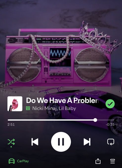 A Spotify CarPlay interface displays the song "Do We Have A Problem" by Nicki Minaj and Lil Baby playing over a backdrop image of a pink boombox, pearl necklaces, a crown, and a pink car.